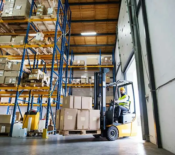 operator carrying stock using crown reach forklift in godown